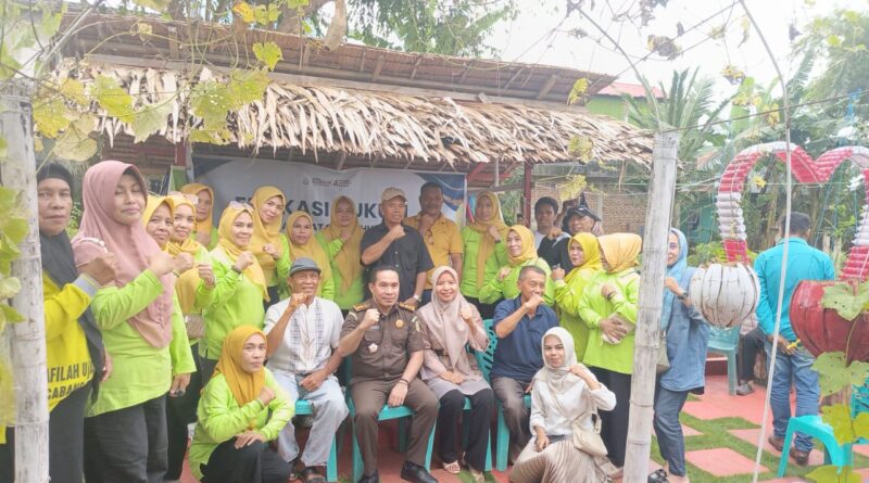 Kepala Seksi Intelijen (Kasi Intel) Kejari Baubau, Abdul Kadir Sangadji memakai pakaian dinas didampingi Lurah BWI Baubau Wa Ode Nurhayati memakai baju Warna cream jilbab Coklat berpose bersama masyarakat usai menggelar edukasi hukum, Sabtu (21/6/2025).